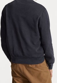 Marinblå sweatshirt gjord av mjukt tyg, med rundad halsringning och ribbade ärmslut. Sitter tajt vid midjan med en ren finish.