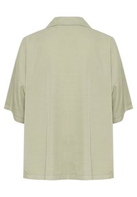 Kreisa piedurkne, gaiši zaļa krekls ar mīkstu tekstūru un platu siluetu. Tam ir apkakle un tīrs, minimālists dizains bez papildu dekorācijām.