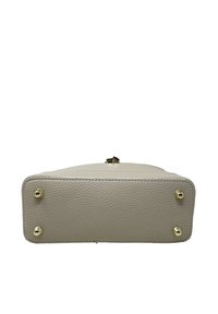 Obdélníková kabelka z krémové kůže s zlatými kovovými prvky a ochrannými kovovými nožičkami na dně. Texturovaný povrch pro odolnost.