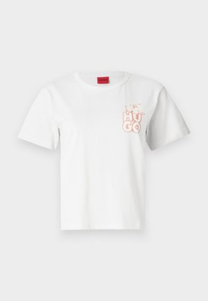 Vit bomull t-shirt med korta ärmar, rund halsringning och en ljusrosa "HUGO"-logotyp tryckt på vänster bröstområde. Röd etikett vid nacken.