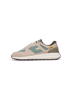 Beige suede sneakers with teal accents, a green rear overlay, and brown laces. Features a white textured sole and yellow logo detail.