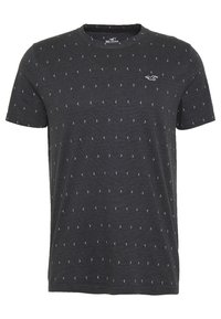 Tmavě šedé bavlněné tričko s krátkým rukávem, s jemným bílým geometrickým vzorem a malým logem na hrudi.