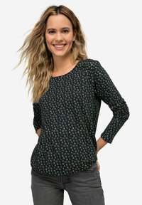 Zwarte shirt met groene tekstpatroon, ronde halslijn, 3/4 mouwen. Zachte stof, relaxte pasvorm en zichtbare stiksels langs de mouwen en zoom.