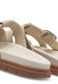 Bež sandale s dizajnom križnih traka, mekanim antilop materijalom, oblikovanim uloškom i gumenom potplatom s logotipom "NATURAL SOFT".