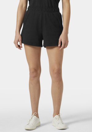 Zwarte katoenen shorts met een elastische tailleband, zijzakken en een losse pasvorm, gecombineerd met witte sneakers. Gladde textuur en eenvoudig ontwerp.