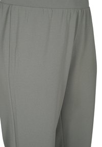 Graue Hose mit einer glatten, weichen Textur, ausgestattet mit einem gerafften Bund. Das Design umfasst Falten an der Seite, die Flexibilität und Komfort betonen.