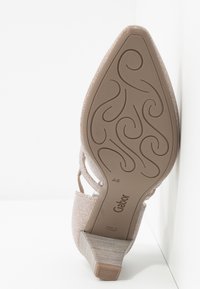 Scarpa con tacco rosa chiaro dal materiale testurizzato, con un tacco basso e curvo e una suola finemente decorata contrassegnata con "Gabor."