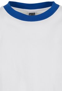 Hvit t-skjorte med blå ribbestrikket rund hals. Stoffet ser mykt ut med en glatt tekstur. "URBAN CLASSICS"-etikett synlig inne i kragen.