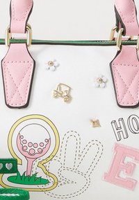 Sac à main blanc avec des anses roses et des accents verts. Comprend des éléments décoratifs : motif de golf, fleurs et texte ludique. Détails brodés présents.