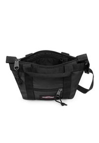 Czarna torba na ramię Eastpak z zamkiem błyskawicznym na górze, przednią kieszonką na zamek, podwójnymi uchwytami i regulowanym paskiem na ramię, pokazana otwarta i pusta.