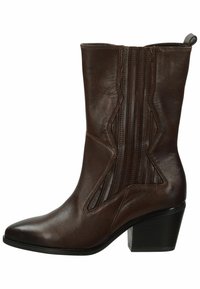 Bota de cuero marrón hasta el tobillo con punta afilada, costuras decorativas y paneles elásticos laterales. Cuenta con un tacón apilado para mayor estabilidad.