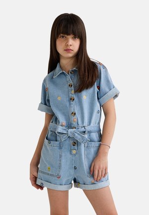 Combishort en denim avec un délavage bleu clair, des manches courtes, un devant à boutons, une taille nouée et une broderie florale multicolore sur les poches et le col.