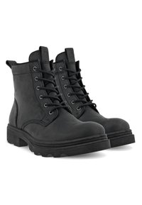 Bottines en cuir noir avec un bout arrondi, une semelle robuste, un laçage sur le devant et une languette. Présente des accents cousus le long des coutures.