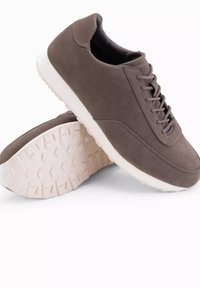 Grå mockaskor med en slät yta, snörning och vit gummisula som har ett strukturerat mönster för bra grepp.