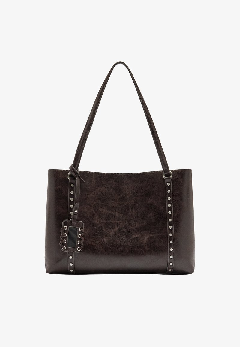 Brązowa skórzana torba na ramię o gładkiej fakturze, z ćwiekami wzdłuż jednej strony oraz odczepianą metką z wplecionym wzorem.