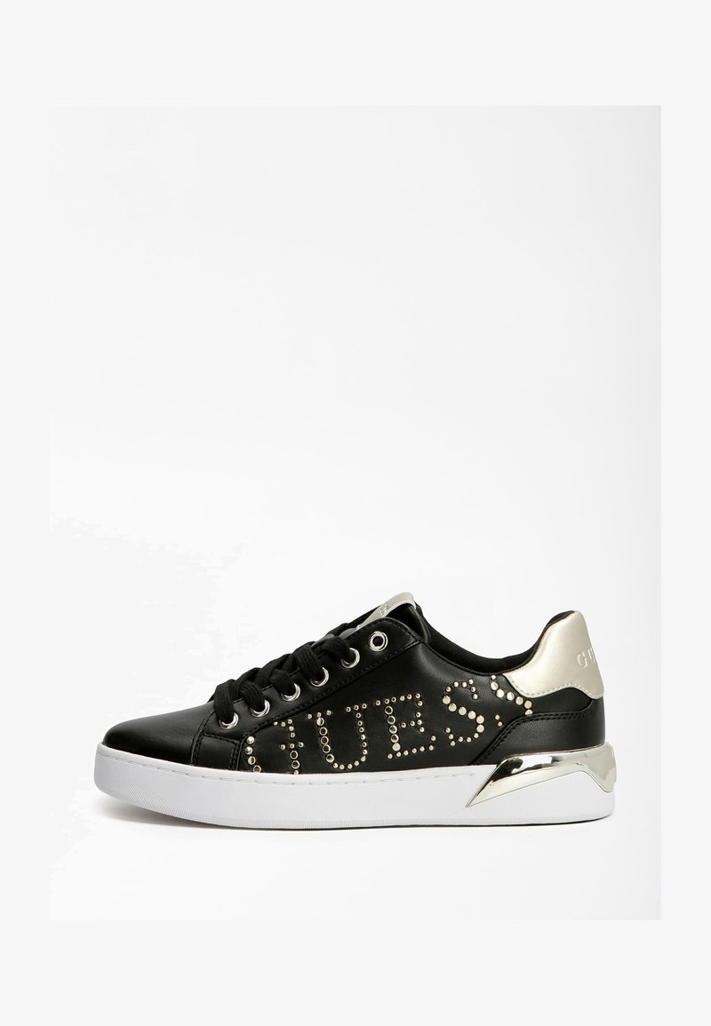 Černé kožené tenisky se stříbrnými detaily, ozdobné logo s hroty, zaoblená špička a bílá podrážka. Obsahují šněrování a vypolstrovaný lem.