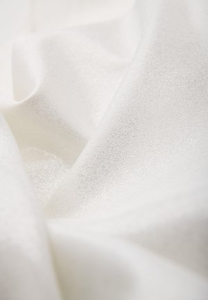 Close-up van zacht wit stof met subtiele glinsterende textuur en zachte plooien.