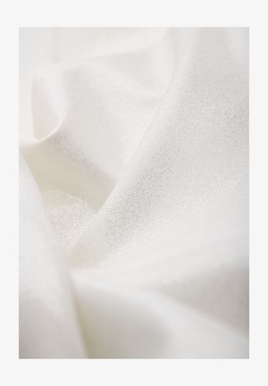 Close-up van zacht wit stof met subtiele glinsterende textuur en zachte plooien.