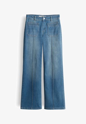 Jean en denim bleu à jambes larges avec poches plaquées à l'avant et coutures verticales visibles, fermeture par bouton et zip à la taille.