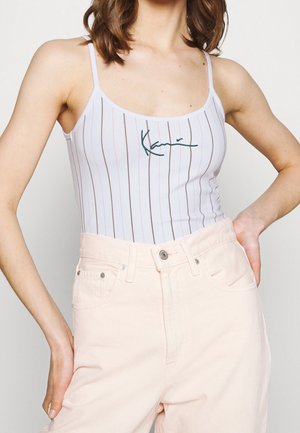 Bílé pruhované body s tenkými ramínky a zeleným vyšívaným textem. Nosit se světle růžovými kalhotami s vysokým pasem. Hladká textura, přiléhavý střih.