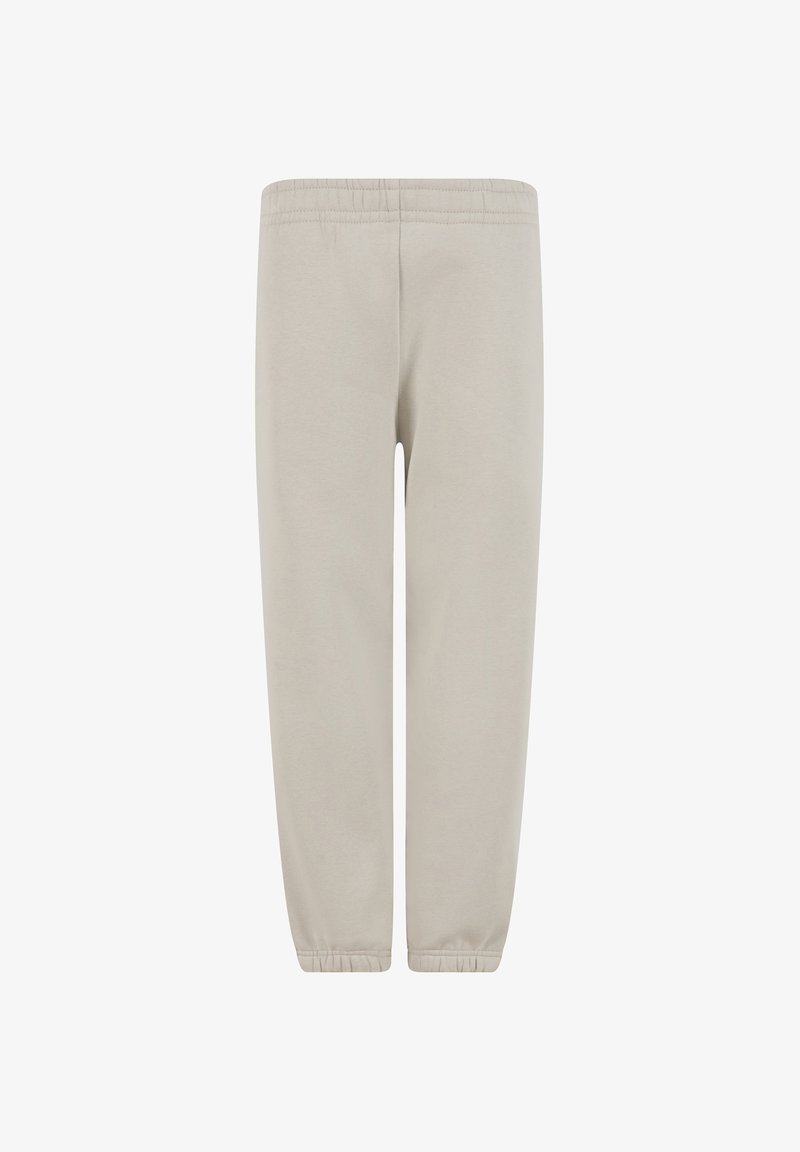 Pantalon de survêtement beige avec ceinture élastique et ourlets côtelés, réalisé en tissu doux, présenté de face sur fond blanc.