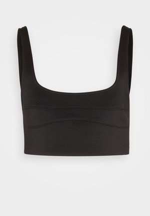 Reggiseno sportivo nero corto con spalline larghe e dettagli tono su tono sulla parte anteriore, mostrato su uno sfondo chiaro uniforme.