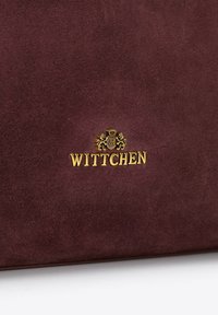 Burgunder aus Wildleder gefertigte Handtasche mit goldfarbenem WITTCHEN-Logo, glatter Textur und einem schlichten Design ohne zusätzliche Beschläge oder Muster.