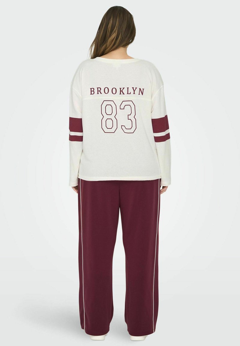 Bílý dlouhý rukáv s vínovými pruhy, s potiskem "BROOKLYN 83" na zádech, ve spojení s volnými vínovými kalhotami s bílými bočními pruhy.