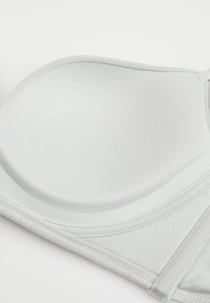Smooth light gray bra cup with soft lining and stitched edges, showing part of the adjustable strap on a plain background.