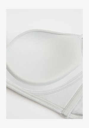 Glatter hellgrauer BH-Cup mit weicher Polsterung und abgesteppten Kanten, zeigt einen Teil des verstellbaren Trägers vor einfarbigem Hintergrund.