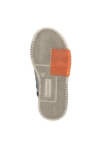 Zool van een schoen met een grijze rubberen basis, voorzien van een uitgesproken visgraatpatroon en een oranje textuuraccent nabij de hak.