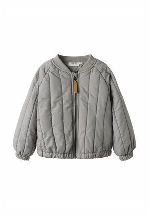 Veste matelassée grise avec fermeture éclair à l'avant, col et poignets côtelés, et une petite étiquette en cuir marron sur le côté gauche. Fini texturé et légèrement brillant.