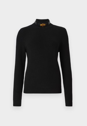 Fekete bordás pulóver hosszú ujjakkal, magas nyakkal és kontrasztos fekete gallérral, amely arany színű fém kiegészítővel díszített.