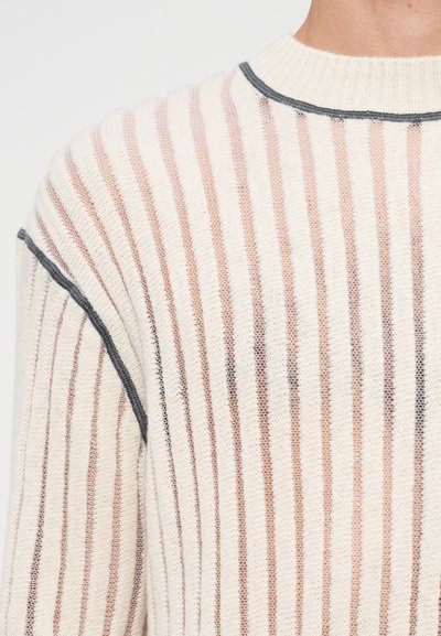 Knitted sweater in cream with alternating thin beige stripes. Features a ribbed neckline and gray detailing along the shoulder seams.
