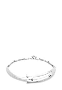 La gargantilla de metal plateado presenta un diseño suave y alargado con dos extremos redondeados y un cierre. El acabado pulido realza el brillo.