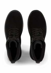 Stivaletti in suede nero alla caviglia con punta tonda, colletto imbottito e design con lacci. Presentano superfici testurizzate e dettagli in metallo a contrasto.