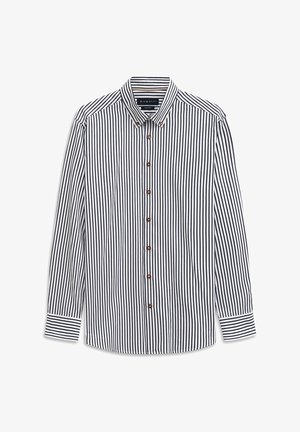 Langarm-Hemd mit schwarz-weiß gestreiften vertikalen Streifen, Knopfleiste, und kontrastierenden horizontalen Streifen an den Manschetten.