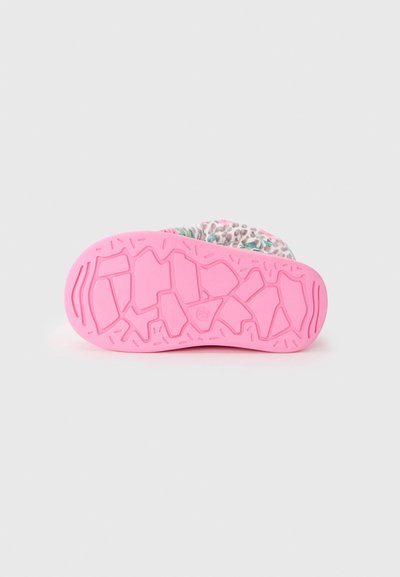 Semelle de chaussure en caoutchouc rose vif avec un motif de texture pour une bonne adhérence. Présente un dessus coloré avec un design floral et animal.