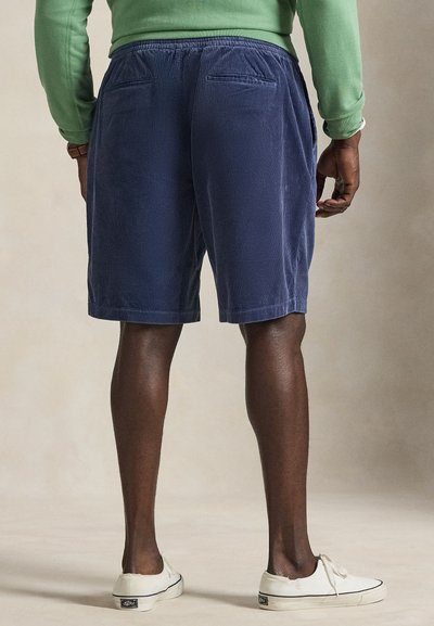 Calções de veludo cotelê azul-marinho com um corte descontraído, apresentando um cós elástico, dois bolsos traseiros e uma textura subtil de riscas verticais.