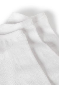 Calzini bianchi in cotone con un motivo a coste testurizzate ai polsini, caratterizzati da un corpo liscio e sezioni rinforzate per il tallone e le punte.