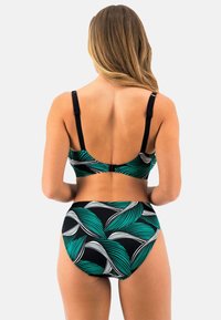 Dvoudílný bikinový set s černým podkladem a zelenými a bílými vzory listů. Měkká tkanina, nastavitelné popruhy a vysoký pas kalhotek.