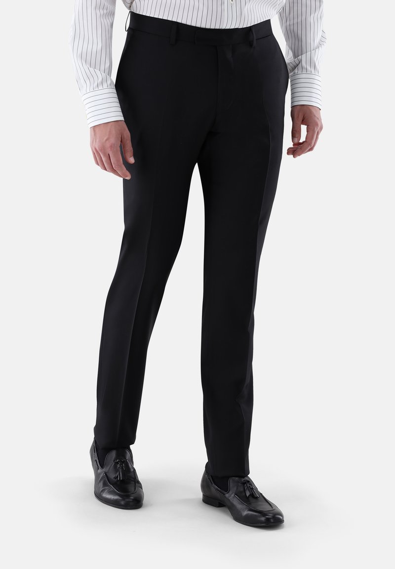 Schwarze, maßgeschneiderte Hose mit glatter Textur, klassischem Schnitt und Bügelfalte. Kombiniert mit einem gestreiften Hemd und schwarzen Schuhen.