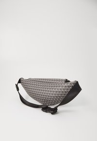 Borsa a tracolla con motivo in bianco e nero, di forma triangolare, in tessuto liscio, con tracolla regolabile e chiusura sicura.