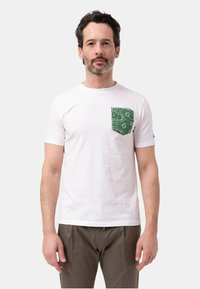 T-shirt bianca in cotone con taschino a motivo verde. Maniche corte, collo a giro, con dettagli di cucitura sottili sull'orlo.