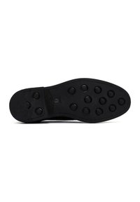 Semelle de chaussure noire avec une surface texturée, présentant des grips en caoutchouc circulaires et une légère courbure, conçue pour l'adhérence et la durabilité.