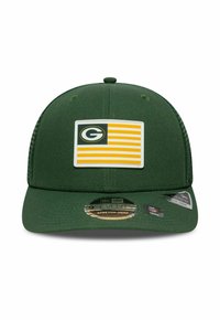 Casquette snapback verte avec un patch sur le devant présentant un drapeau rayé jaune et blanc et un logo circulaire, fabriquée en tissu avec une forme structurée.