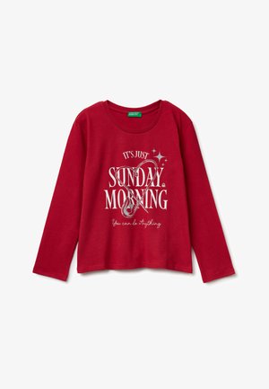 T-shirt rossa a maniche lunghe in cotone, con scollatura rotonda e stampa grafica con il testo "È SOLO UNA DOMENICA MATTINA" in bianco.