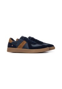 Zapatillas de deporte azul marino que combinan materiales de gamuza y cuero, una franja de acento en tono beige, y una suela de goma con un patrón texturizado.