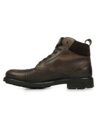 Stivali alla caviglia in pelle marrone con collare in suede, punta rotonda, chiusura con lacci e suola in gomma nera texture. Presentano un tassello sul tallone.