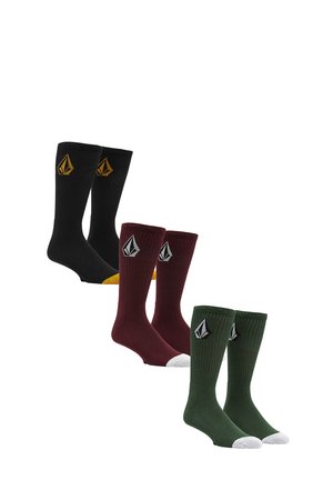 Trois paires de chaussettes montantes : noires avec des accents jaunes, bordeaux et vert avec des orteils blancs ; toutes présentent un design texturé à côtes.